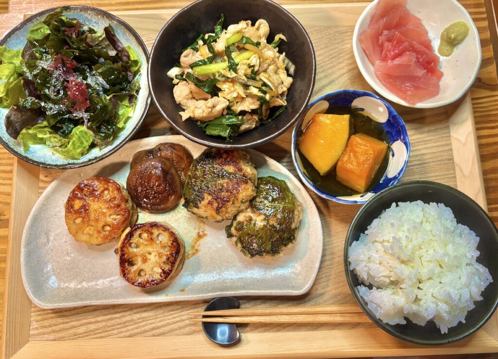 大分県の郷土料理ニラ豚を中心に、マグロの刺身、かぼちゃの煮物、海藻サラダ、大葉と梅肉入り鶏ミンチのれんこん挟み焼き、大葉と刻みれんこん入り豚つくね、ごはんを並べた和定食の食卓風景。