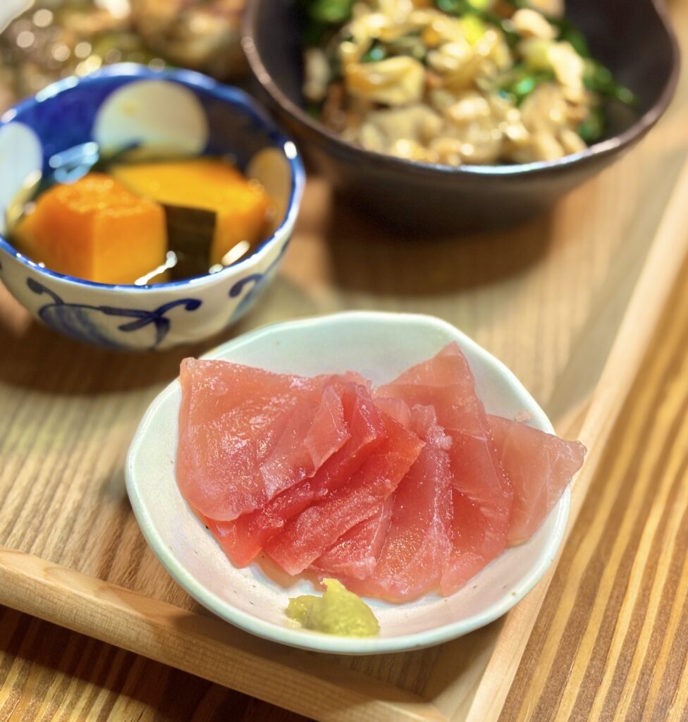 鮮やかな赤身のマグロの刺身を小皿に盛り、わさびを添えたシンプルで美しい一品。