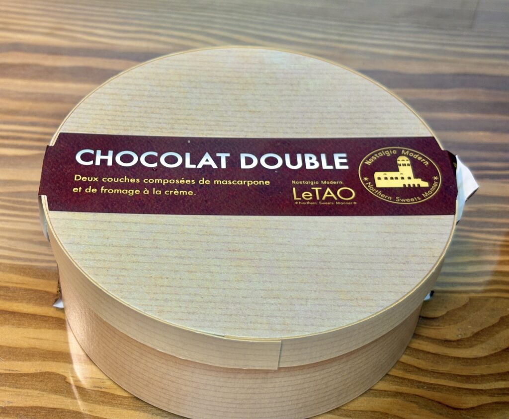 LeTAOのショコラドゥーブルを木箱風パッケージで撮影した写真。シンプルで高級感のある丸い箱にショコラドゥーブルのロゴが入ったスイーツギフト。