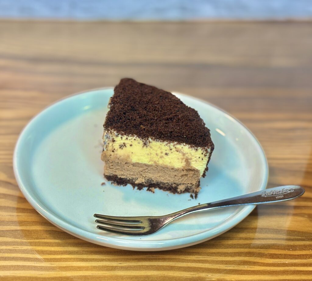 ルタオのショコラドゥーブルをカットした一切れを皿に盛り付けた写真。チョコレート層とマスカルポーネチーズの二層が美しい濃厚チーズケーキ。