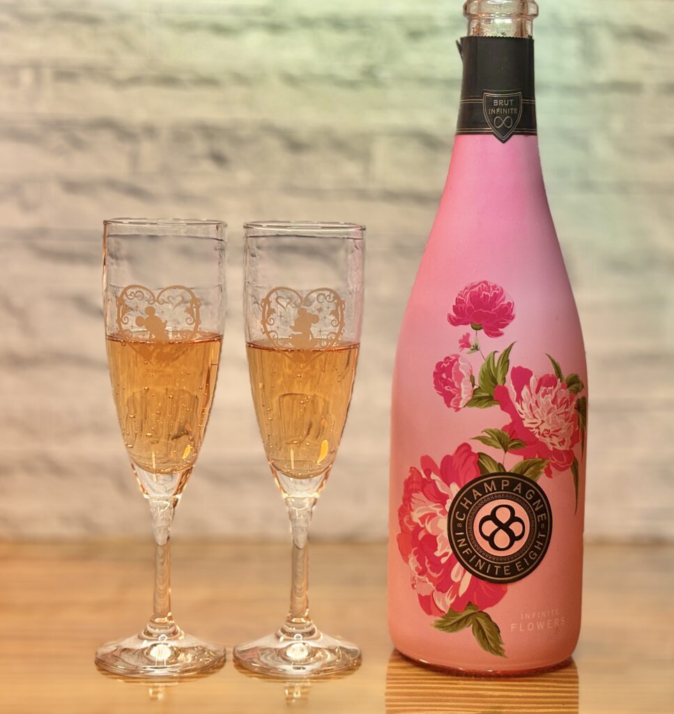 ピンク色のボトルが特徴的なシャンパンとグラスを並べた乾杯シーン