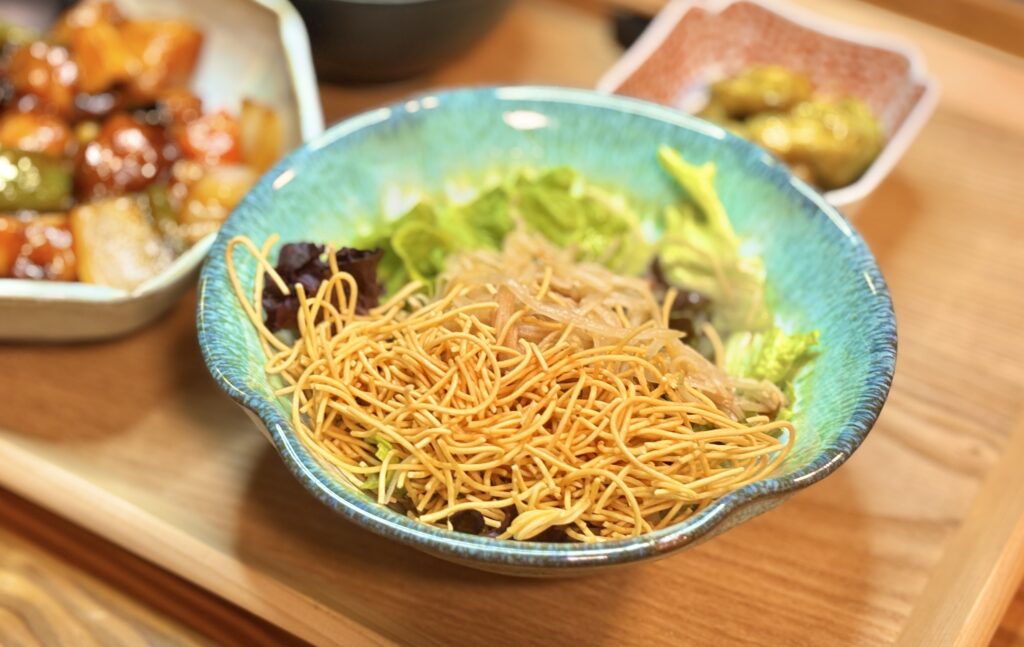 パリパリの揚げ麺がたっぷりトッピングされた、カニカマともやしのラーメンサラダのアップ写真