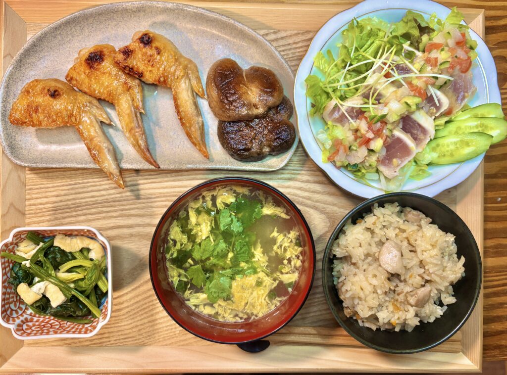 手羽先と椎茸の塩焼き、ビンチョウマグロのカルパッチョ、鳥飯、三つ葉のお吸い物、ほうれん草と揚げの出汁煮を並べた和食の食卓全体