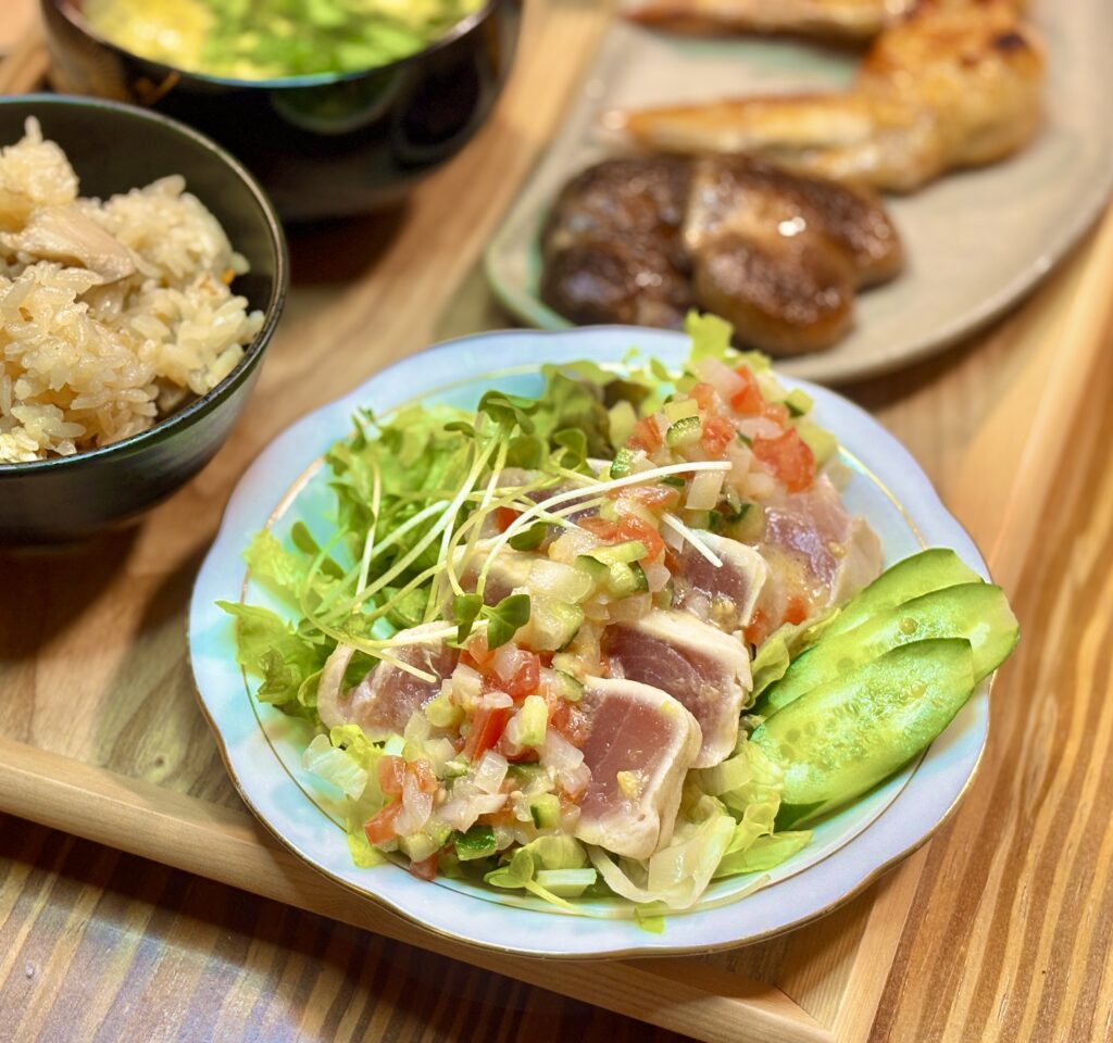 ビンチョウマグロのカルパッチョにラビゴットソースをかけ、レタスときゅうりを添えた一皿