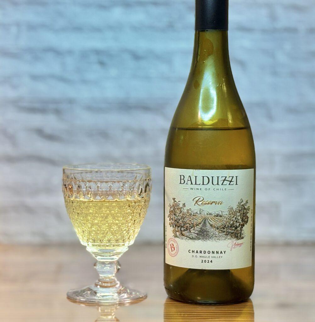 チリワイン「BALDUZZI（バルドゥッツィ）」のボトルと、レトロなカットグラスに注がれた白ワイン
