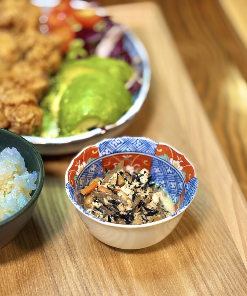 彩り豊かな和柄の器に盛り付けられた、ひじきと豆腐、にんじんの煮物のアップ写真
