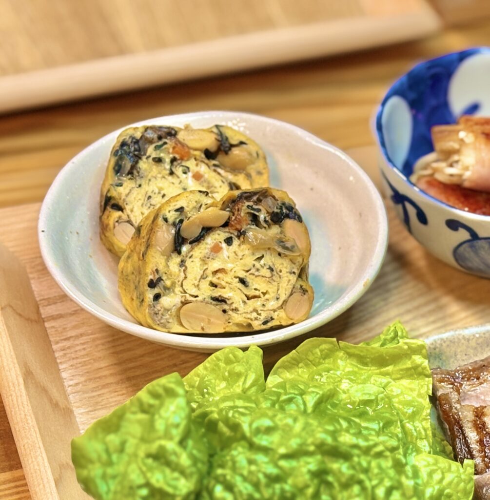 ひじき、大豆、人参などの具材がたっぷり入った、断面の美しい厚焼き卵のアップ。