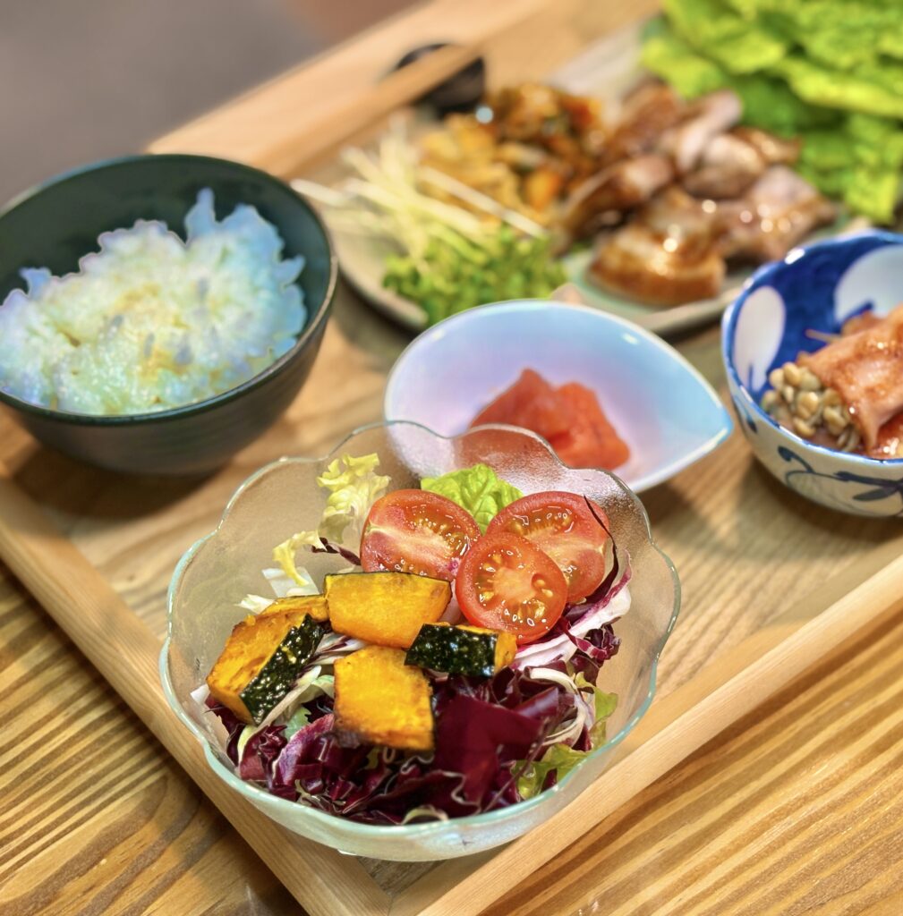 ガラスの器に盛られた、素揚げしたかぼちゃ、ミニトマト、紫キャベツ、レタスのフレッシュなサラダ。