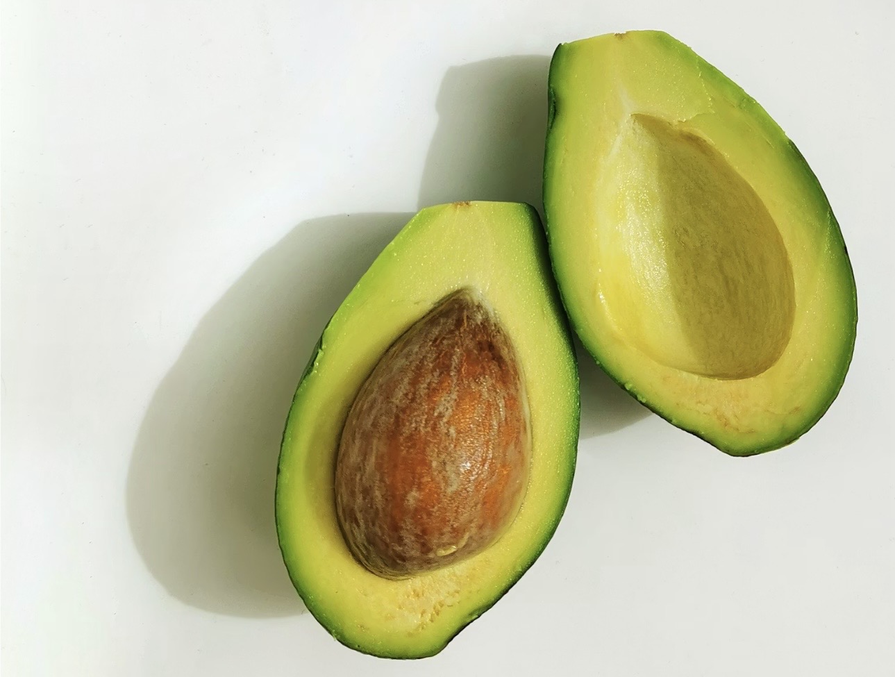 半分にカットされた新鮮な完熟アボカドの断面写真