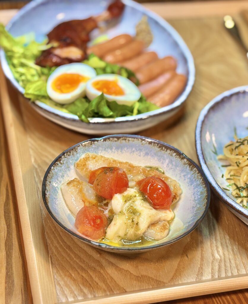 笹かまぼこのマルゲリータ風アレンジ。半分に切ったミニトマトととろけるチーズ、バジルソースをかけて焼いた、彩り豊かな洋風おつまみレシピ