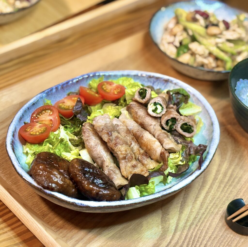 レタスの上に並べた豚ロースの紫蘇チーズ巻きと照りよく焼いた肉厚椎茸、ミニトマトを添えたメインプレートのアップ