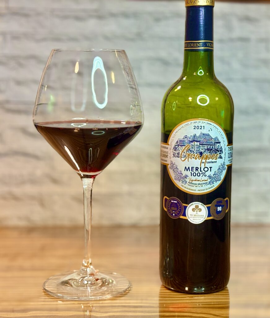 金賞受賞のボルドーワインと赤ワイングラスを並べた家飲みシーン、落ち着いた雰囲気のテーブル写真
