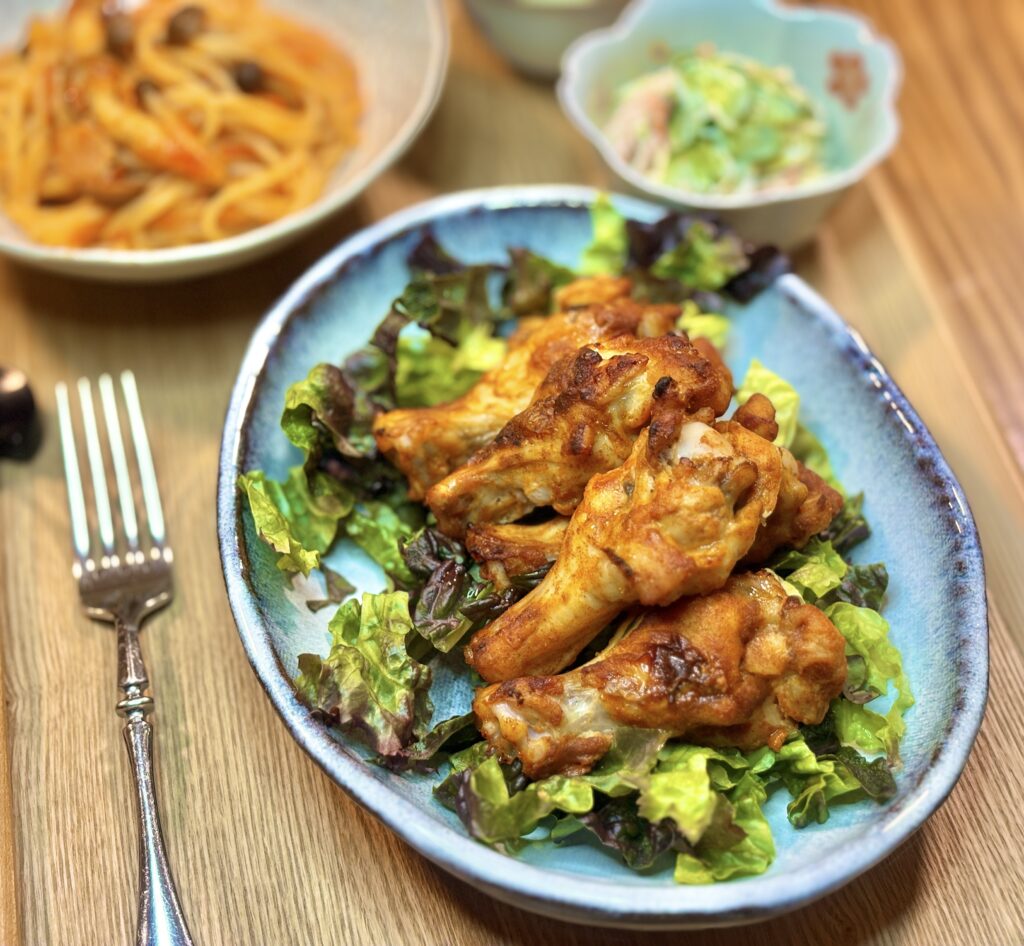 レタスの上に盛り付けられたタンドリーチキンのクローズアップ。こんがり焼き色がついたチキンがジューシーに仕上がっている。