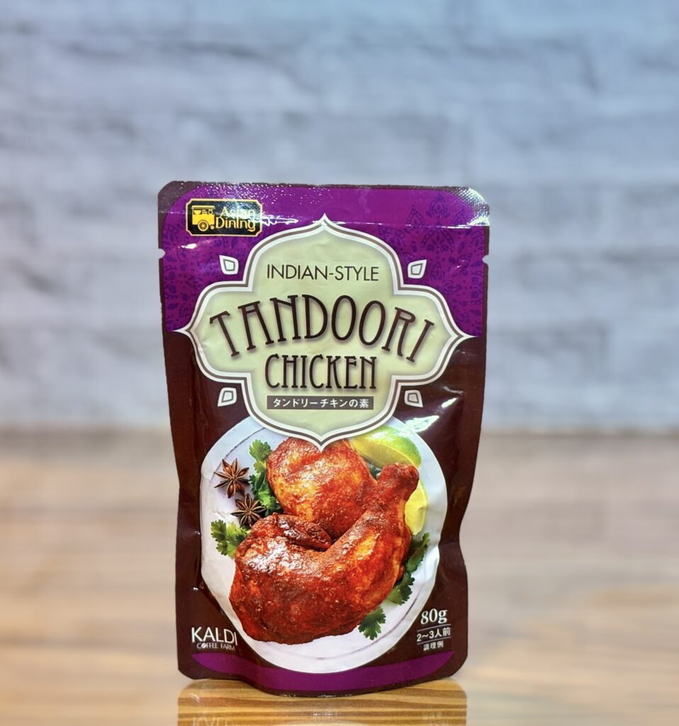 カルディのタンドリーチキンの素のパッケージ。紫色のパウチにスパイス香るチキンの写真がデザインされている。