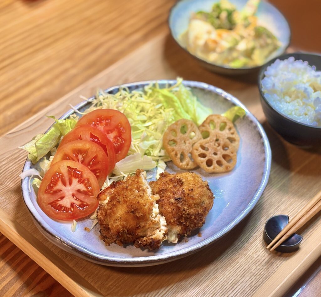 鶏ささみ肉のトマトチーズ挟み揚げのメインプレート。サクサクの衣で揚げたささみフライにレンコンの素揚げ、トマトスライスとキャベツサラダを添えた家庭料理の一皿。