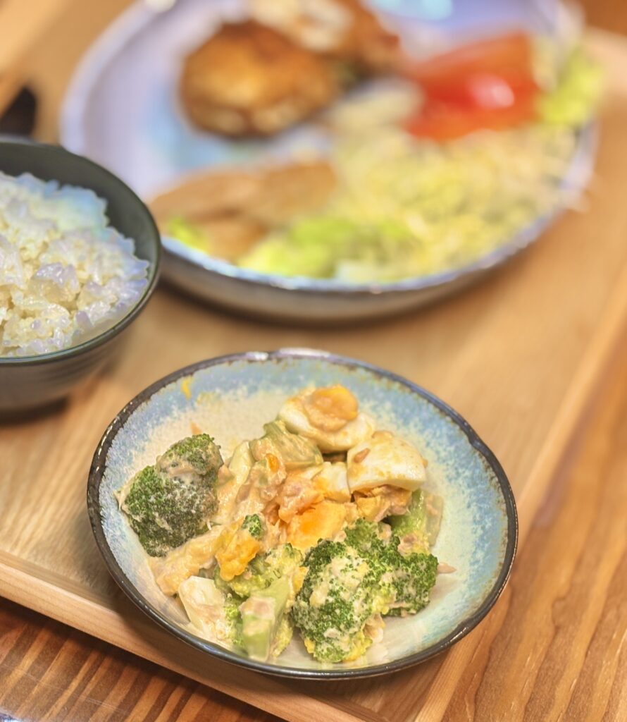 ゆで卵とブロッコリーをツナマヨネーズで和えた副菜の小鉢。クリーミーなツナマヨとブロッコリー、ゆで卵を合わせた家庭の定番サラダ。
