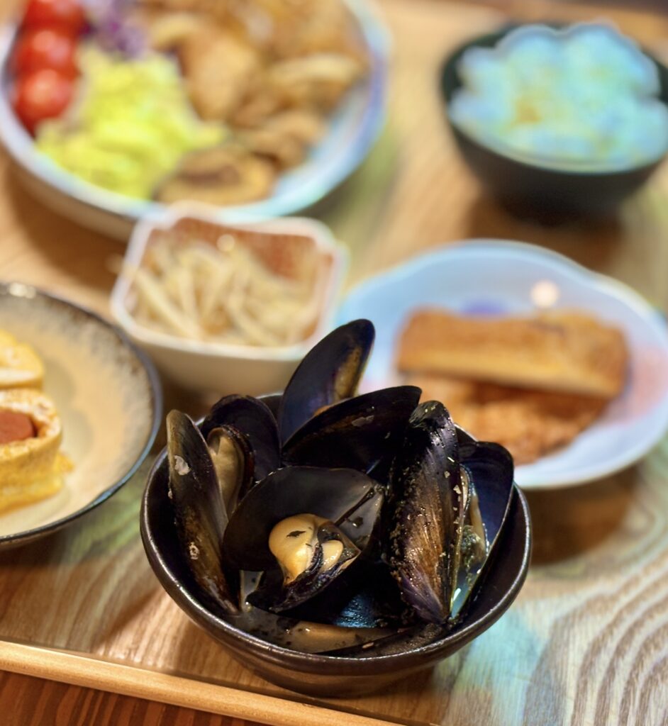 黒い器に盛り付けたムール貝のワイン蒸し。殻が開いたムール貝から旨味たっぷりのスープが見える、家飲みにぴったりの一品。
