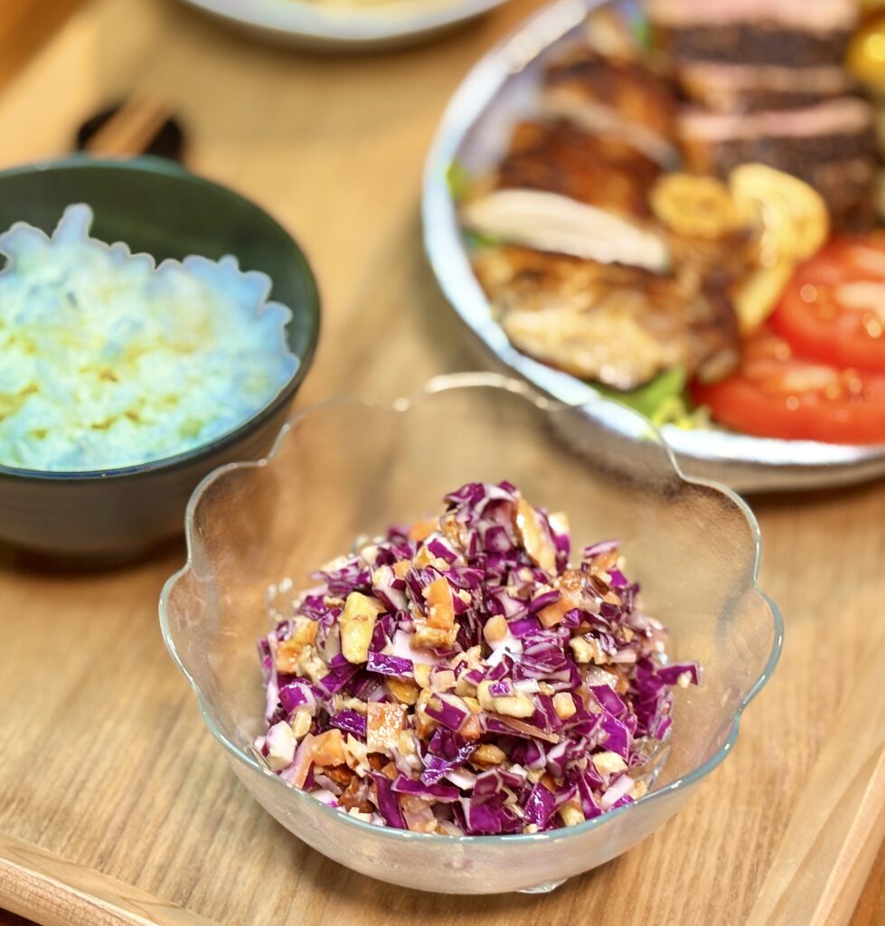 紫キャベツとにんじんを細かく刻み、ミックスナッツを加えて市販のコールスロードレッシングで和えた彩り鮮やかなコールスローサラダ。シャキシャキ食感とナッツの香ばしさが楽しめる副菜。