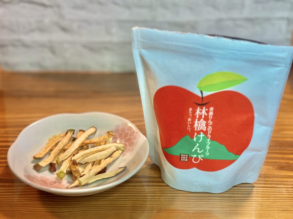 栃木名物のドライフルーツ菓子、林檎けんぴのパッケージと皿に盛ったりんごスティック。カリッとした食感が特徴のりんごのおやつ。
