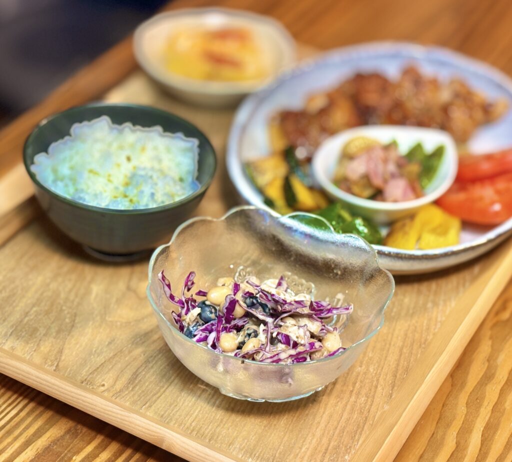 紫キャベツ、鶏胸肉、ミックスビーンズを胡麻ドレッシングで和えた彩りサラダ。ハニーマスタードチキンの献立に添えられた栄養たっぷりの副菜。