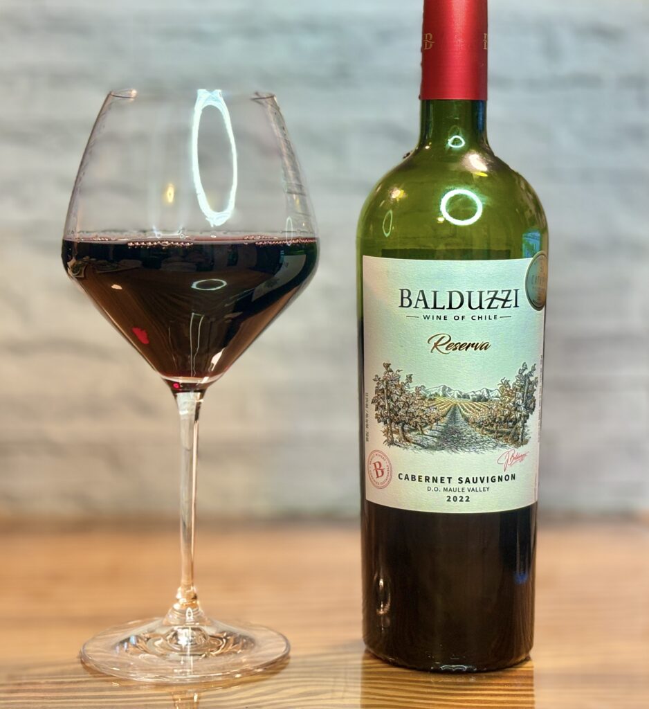BALDUZZI Reserva Cabernet Sauvignon 2022の赤ワインボトルとグラスを並べたワインペアリング写真。肉料理に合うチリのカベルネソーヴィニヨン。