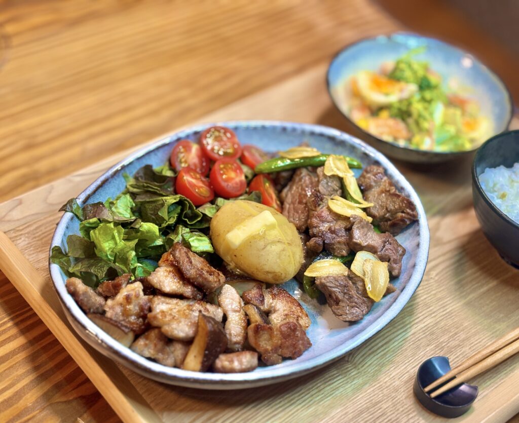 サイコロステーキとスナックえんどうのガーリック炒め、トンテキ椎茸焼き、中央にじゃがバターとミニトマトサラダを盛り付けたお肉たっぷりのワンプレート。