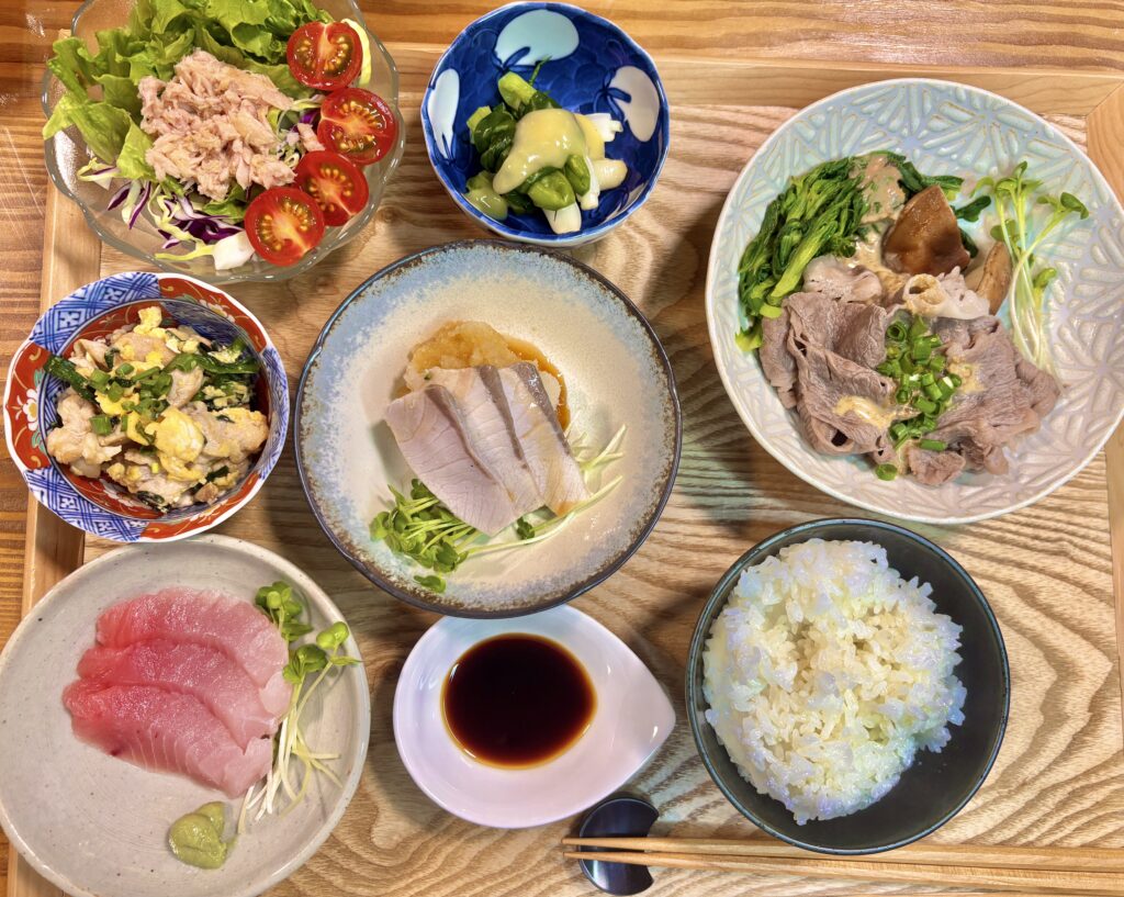 黒毛和牛しゃぶしゃぶと鰤しゃぶを中心にした和食献立の全体写真。桜ビンチョウマグロのお造りやわけぎの酢味噌和え、ツナサラダなどが並ぶ豪華な食卓。