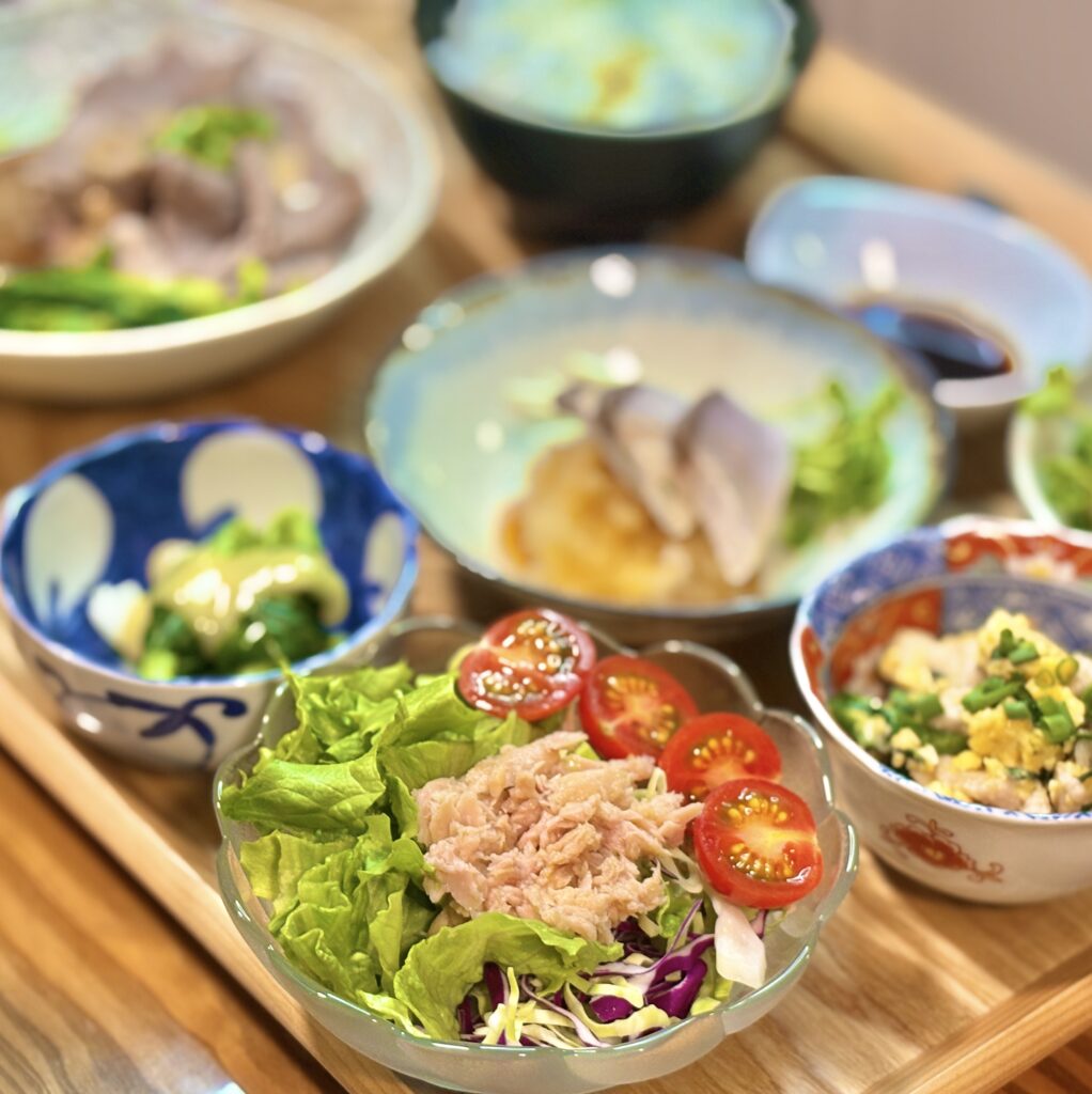 ツナとレタス、紫キャベツを合わせたサラダにミニトマトを添えた一皿。さっぱりとした副菜で和食の食卓に彩りを添える。