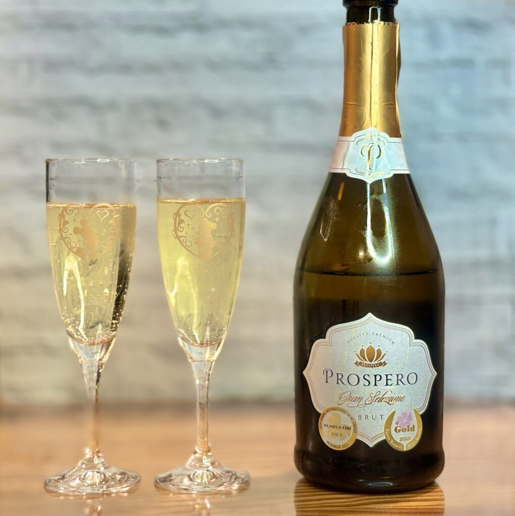 スパークリングワイン「プロスペロ グラン セレツィオーネ ブリュット」とグラス2杯。お祝いの食卓にぴったりの乾杯シーン。