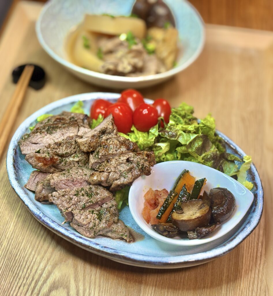 ラム肉ステーキと野菜サラダ、かぼちゃとベーコンとマッシュルームのガーリック炒めを添えたワンプレート料理