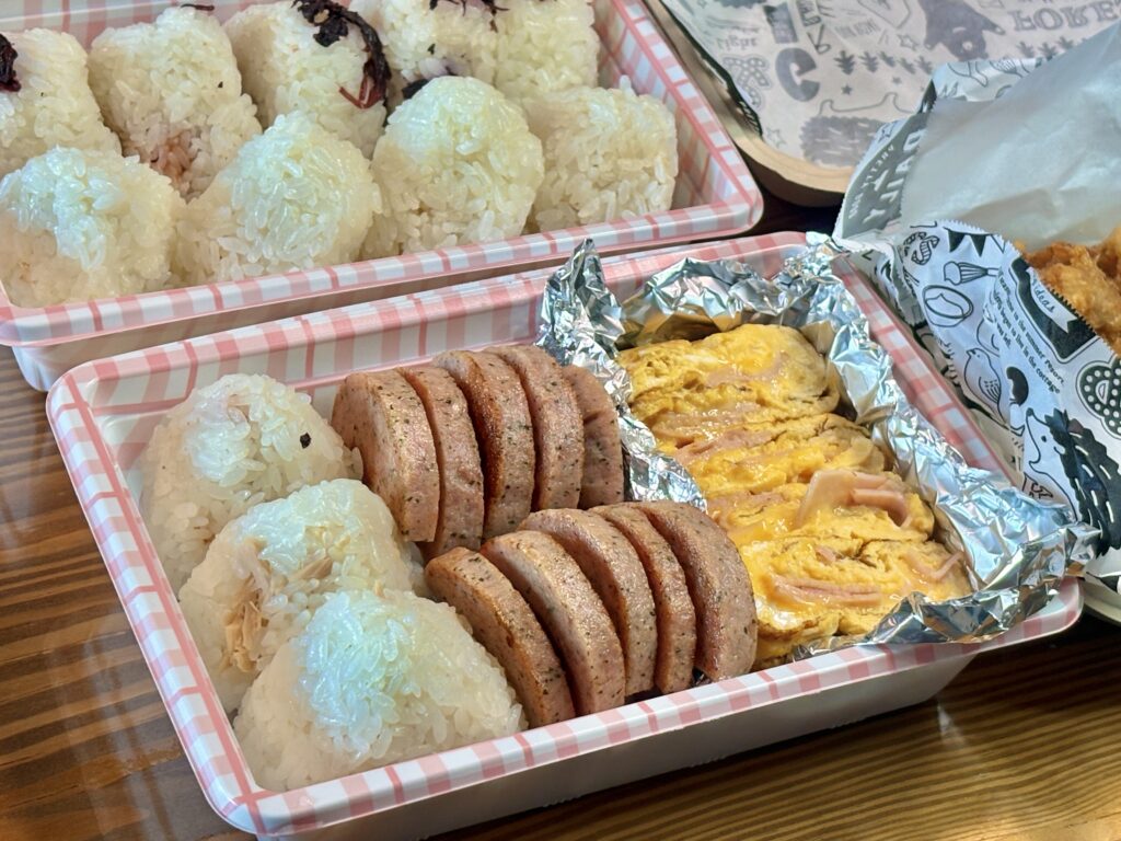 明宝ソーセージとハムチーズ入り卵焼き、おにぎりが並ぶお弁当|彩り豊かな手作りお花見弁当のアップ写真