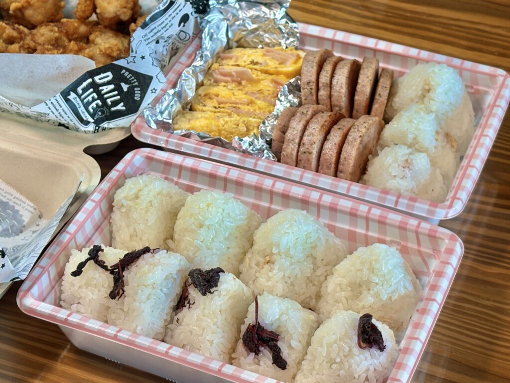 手作りお弁当のおにぎりと明宝ソーセージと卵焼きと唐揚げの盛り付け写真|梅とツナマヨのおにぎりが並ぶ家庭のお弁当