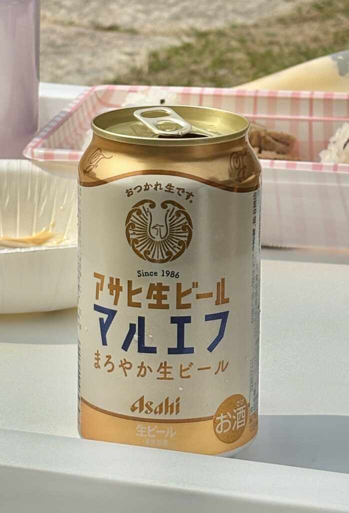 アサヒ生ビールマルエフの缶ビールを屋外で撮影した写真|お弁当と一緒に楽しむまろやかな生ビールのある休日シーン