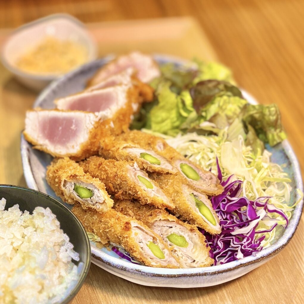 アスパラの豚肉巻きフライの断面。緑のアスパラがきれいに並ぶ萌え断。キハダマグロのレアカツと盛り合わせた旦那キッチンの揚げ物プレート
