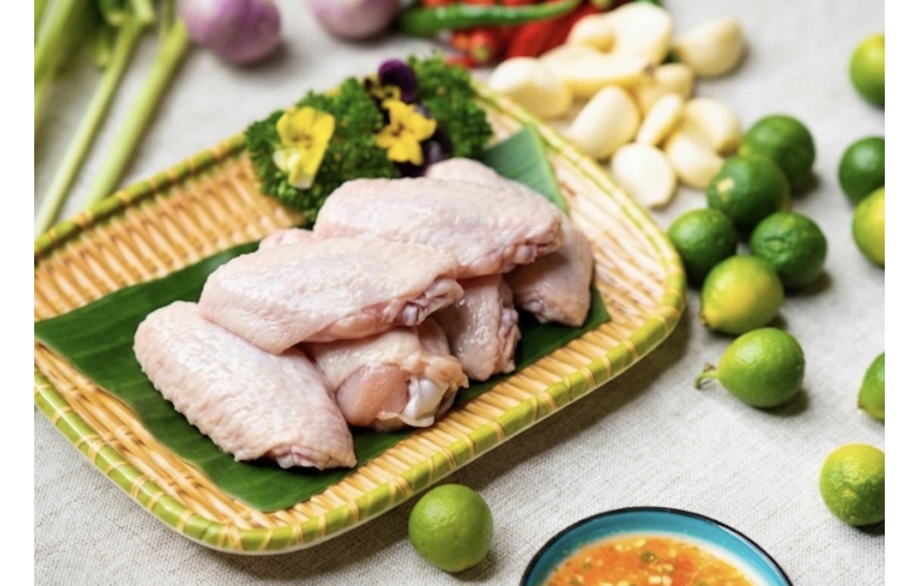 ライムやにんにく、唐辛子と一緒に並べた生の手羽先の食材写真。手羽先レシピや下味調理、唐揚げ、グリル料理のイメージに使える一枚