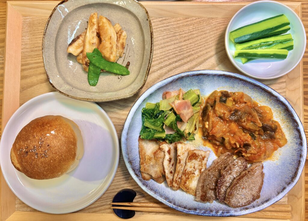 ラタトゥイユと牛豚ロース焼き・ロメインレタスとベーコンのマヨネーズ炒めのワンプレート。奥にはブールアンジュ梅田のパンとタケノコの唐揚げ