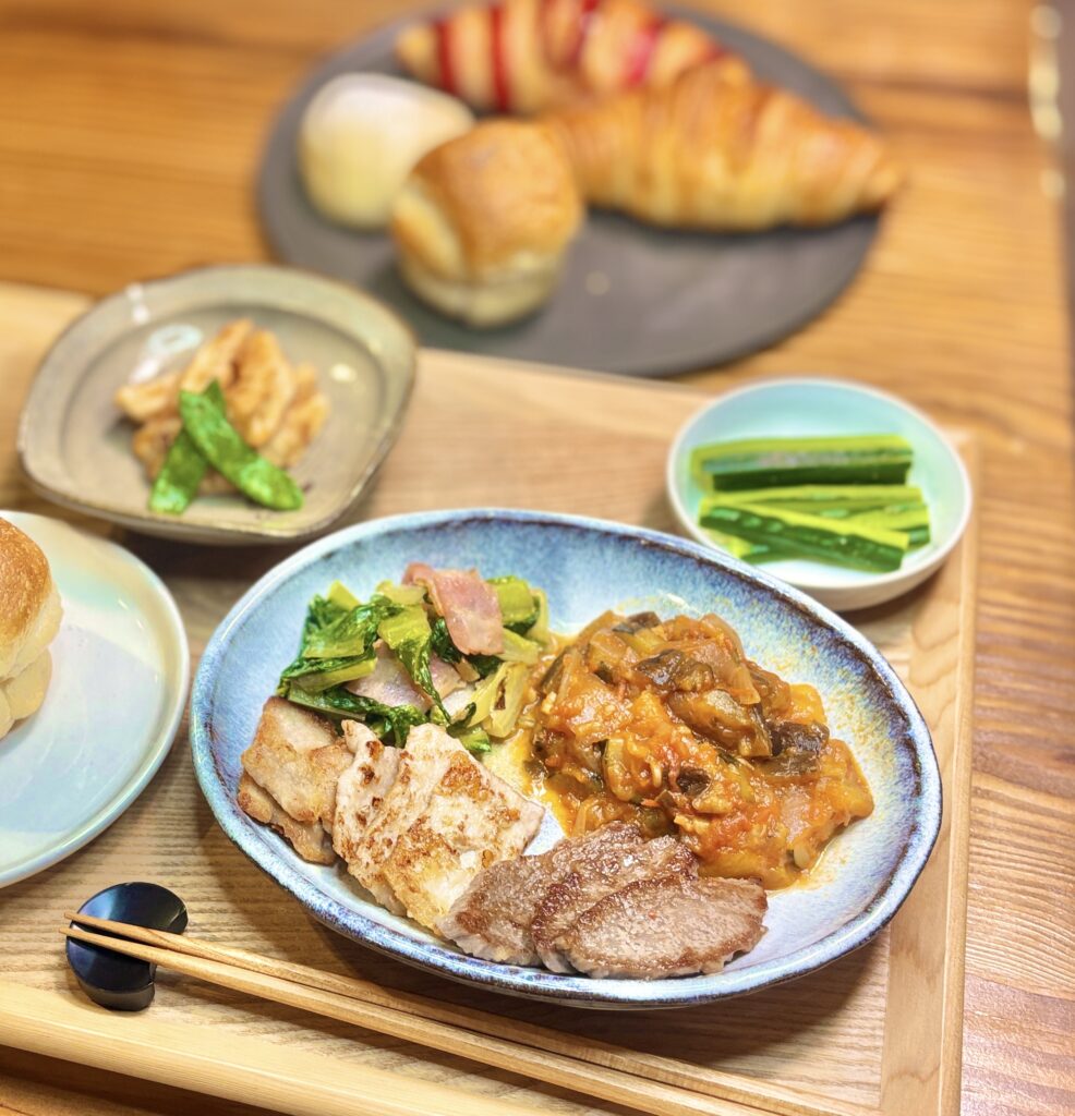 ラタトゥイユと牛豚ロース焼き・ロメインレタスとベーコンのマヨネーズ炒めのワンプレート。奥にはブールアンジュ梅田のパンとタケノコの唐揚げ