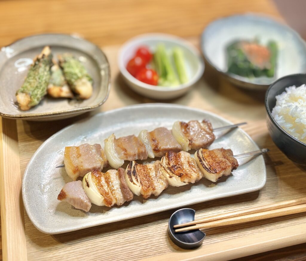 塩麹で下味をつけて焼き上げた豚バラ肉の串焼き。玉ねぎと交互に刺したジューシーな焼き串で、香ばしい焼き色と旨みが際立つ簡単おつまみレシピ。