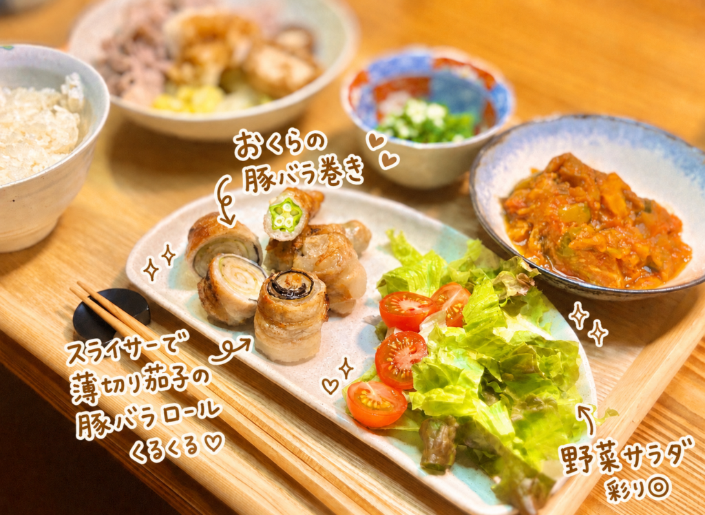スライサーで薄切りにした茄子の豚バラロールと、おくらの豚バラ巻きを中心に、野菜サラダを添えた旦那キッチンの晩ごはん写真。香ばしく焼けた豚バラ巻きは、茄子のくるくるした断面やおくらの星形の断面が見えて、見た目も楽しい一皿。白い手書き文字で可愛く料理名を入れた、豚バラ巻きレシピや野菜たっぷり献立に使いやすい画像。
