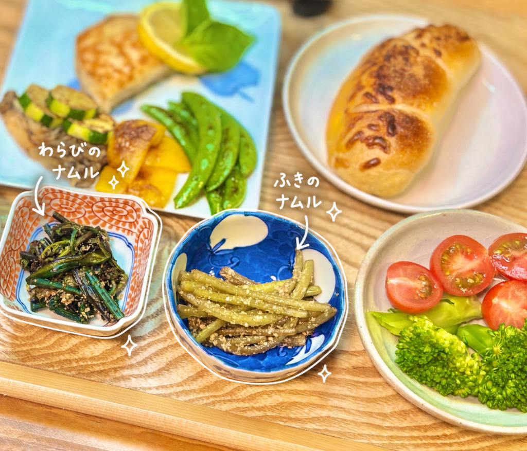 わらびのナムルとふきのナムルを中心に、真鯛のムニエル レモンバターソース、焼き野菜、ブロッコリーとミニトマト、コープの塩バターチーズパンを合わせた旦那キッチンのおうちビストロ風晩ごはん。