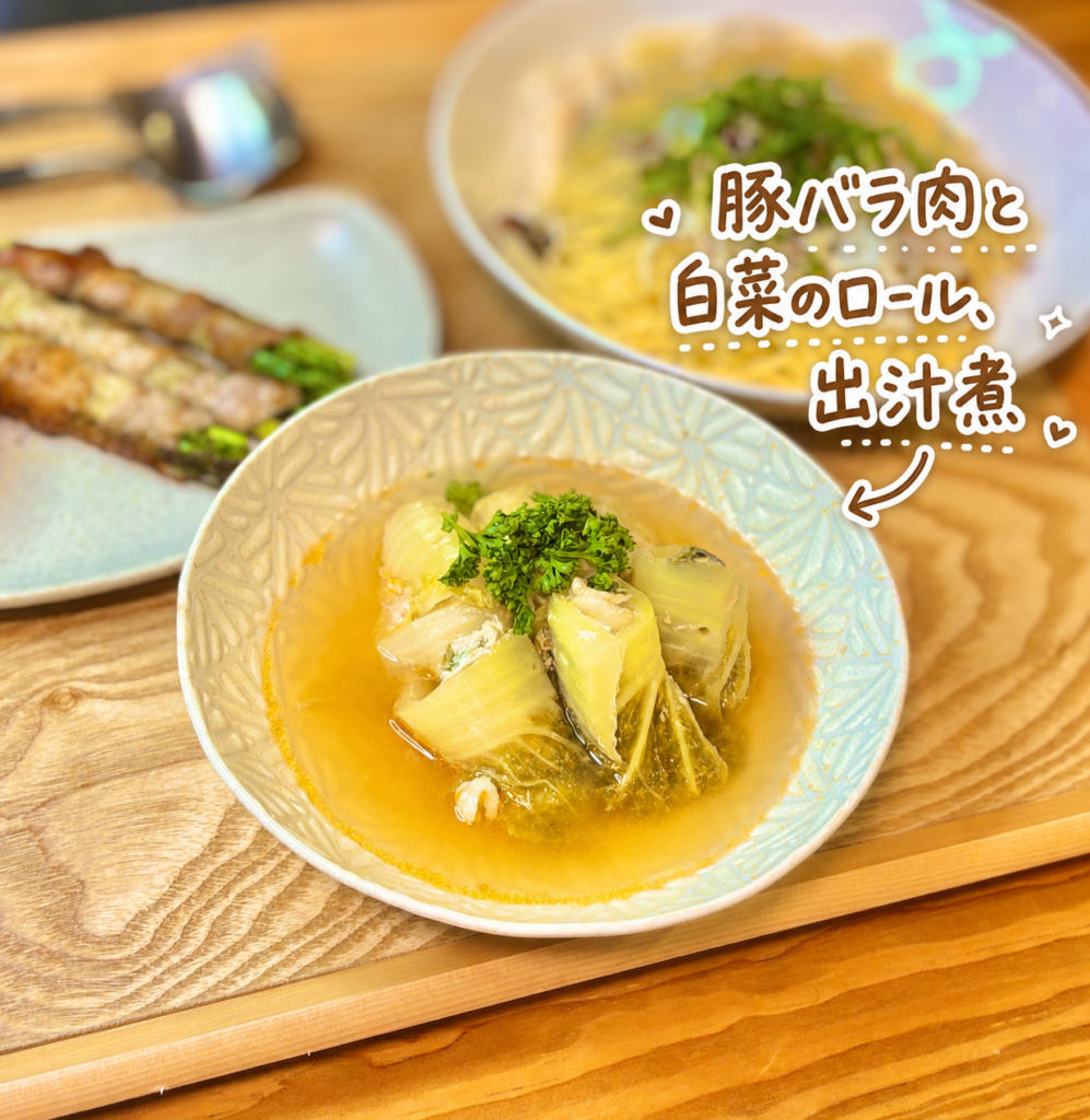 豚バラ肉と白菜のロール出汁煮を主役にした、温かみのある家庭料理の写真です。淡い色合いの器には、やわらかく煮込まれた白菜ロールが盛りつけられ、黄金色の出汁がたっぷり注がれています。白菜の中には豚バラ肉の旨みが包まれており、出汁のやさしい香りと豚バラのコクが感じられる、ほっとする一品です。仕上げに緑のパセリが添えられ、見た目にもやさしく上品な印象になっています。写真右上には、豚バラ肉と白菜のロール、出汁煮という手書き風の可愛い文字と矢印、ハートやきらきらの装飾が入っており、旦那キッチンの晩ごはん記事に使いやすい雰囲気です。白菜ロールレシピ、豚バラ白菜、出汁煮、やさしい和風おかず、冬の家庭料理、晩ごはん献立として紹介する画像に適しています。