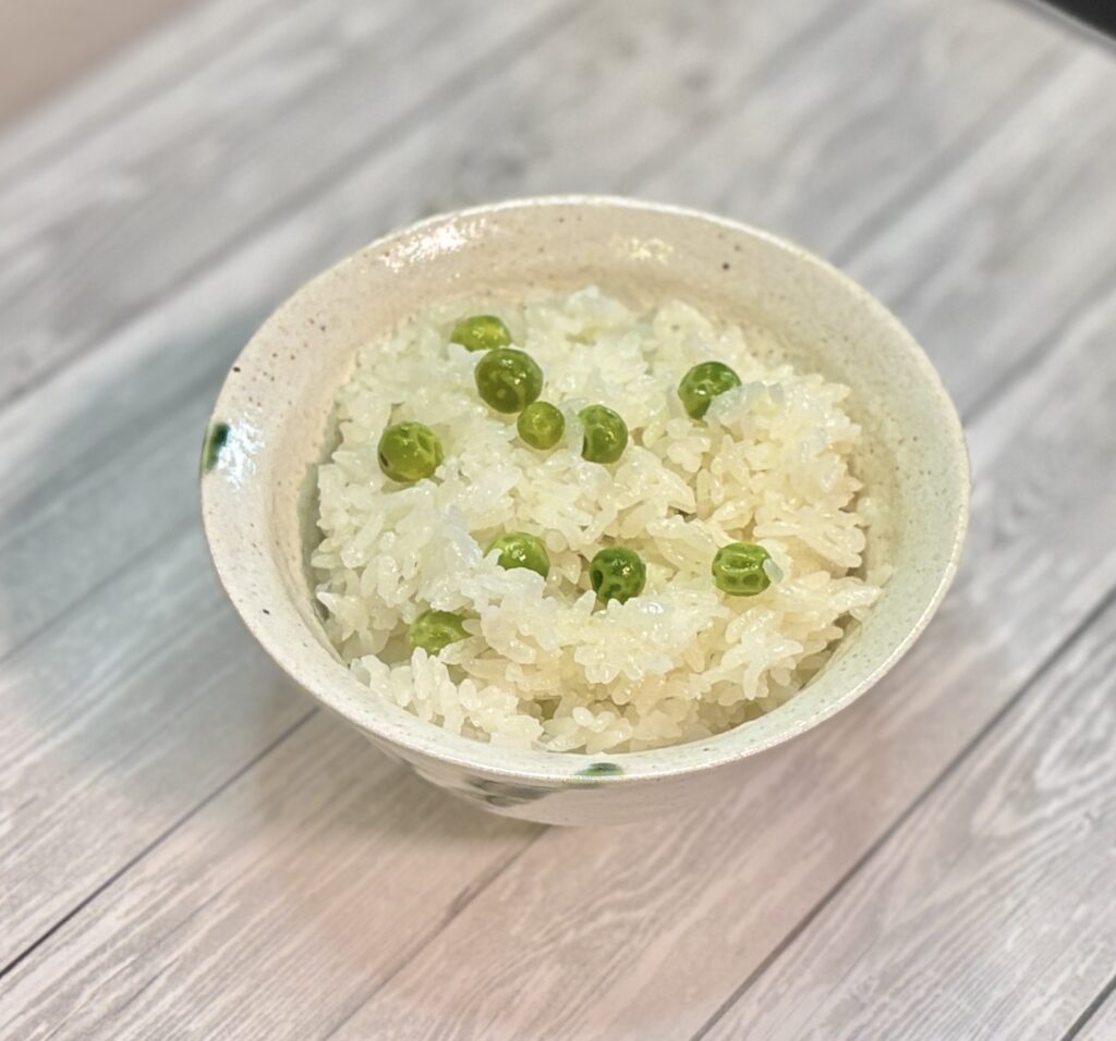 グリーンピースを別茹でして後混ぜした季節の豆ご飯。ふっくら炊き上げた白ご飯に鮮やかな緑が映え、甘みとほくほく食感が楽しめる春の定番レシピ。簡単に作れるおうちごはんにぴったりの一品。