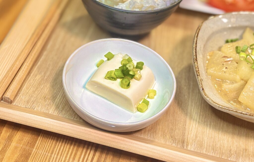 小鉢に盛り付けた冷奴に青ねぎをのせた簡単副菜。豚ヒレカツとチキンカツの揚げ物献立に添えたさっぱりおかず