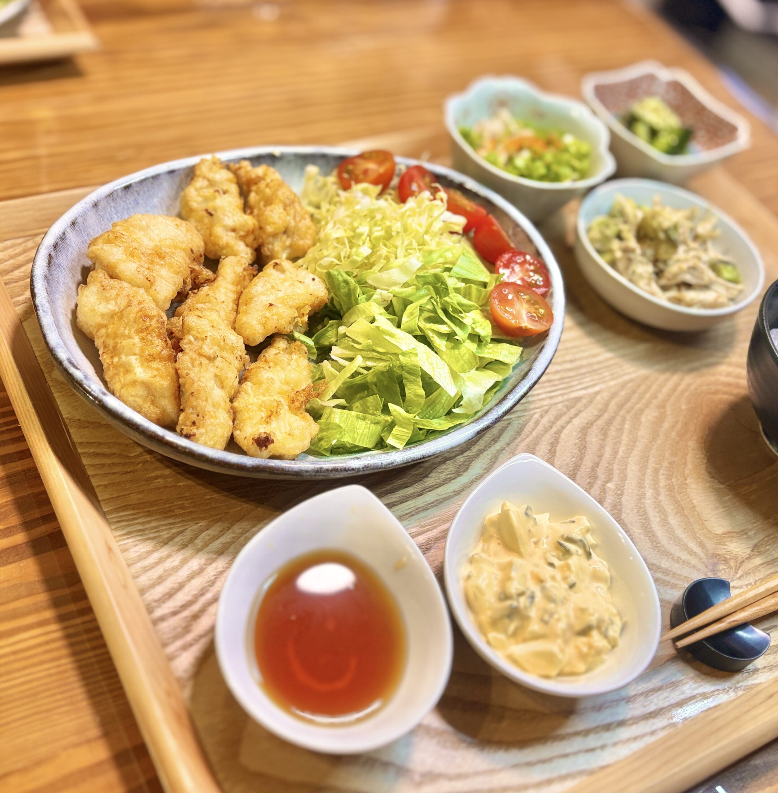 チキン南蛮に野菜サラダ、南蛮酢、タルタルソースを添えた晩ごはん献立。鶏皮ポン酢、鶏胸肉とアボカドのゴマだれ和え、叩ききゅうりのゆかり和えも並ぶ鶏づくしのおうちごはん