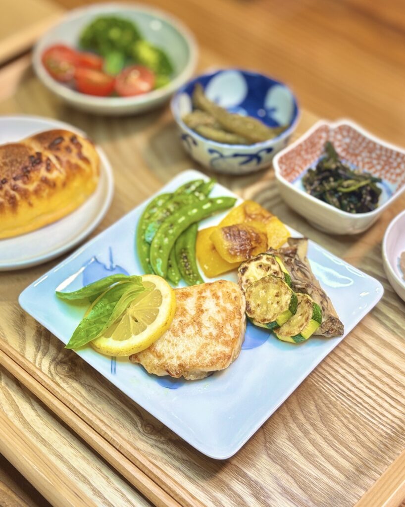 真鯛のムニエル レモンバターソースを主役に、スナックえんどう・パプリカ・ズッキーニ・舞茸の焼き野菜、鳥レバーのパテ、ふきとわらびのナムル、ブロッコリーとミニトマト、コープの塩バターチーズパンを合わせたおうちビストロ風晩ごはん。