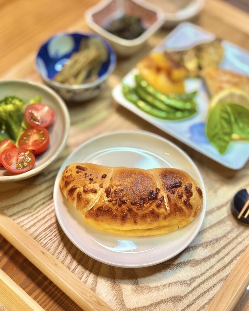 コープの塩バターチーズパンを主役に、真鯛のムニエル レモンバターソース、焼き野菜、ふきとわらびのナムル、ブロッコリーとミニトマトを合わせた旦那キッチンのおうちビストロ風晩ごはん。