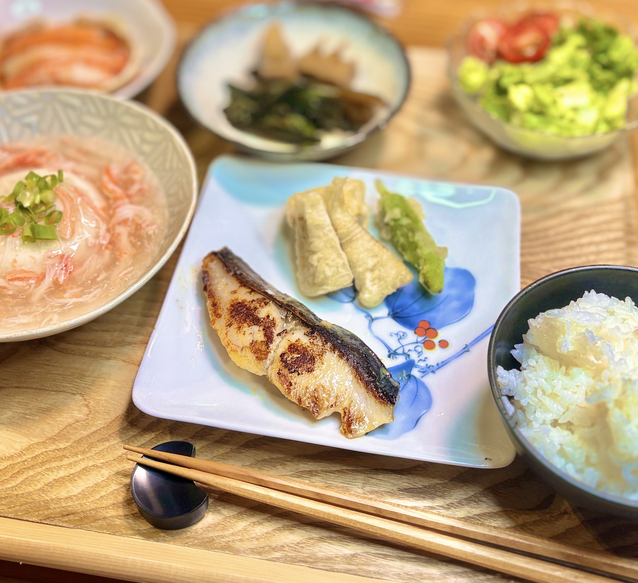 前日から味噌に漬け込んだ自家製サワラの西京焼きを主役に、タケノコとししとうの天ぷら、紅ズワイカニのあんかけ豆腐、白ごはんを添えた贅沢和食献立の写真。
