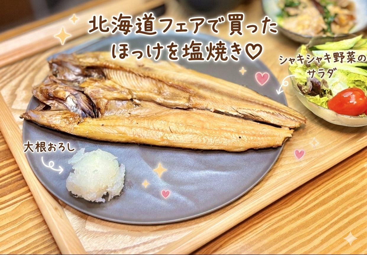 北海道フェアで買った大きなほっけを塩焼きにした、旦那キッチンの和食晩ごはん写真です。グレーのお皿に香ばしく焼かれたほっけの開きがどーんと盛りつけられ、横にはさっぱり食べられる大根おろしが添えられています。木製トレーの上には、シャキシャキ野菜のサラダやニラと豚バラ椎茸の出汁卵とじも並び、焼き魚を中心にした家庭的な和食献立の雰囲気が伝わります。写真には「北海道フェアで買ったほっけを塩焼き」「大根おろし」「シャキシャキ野菜のサラダ」という可愛い手書き風の文字入れがあり、ほっけの塩焼き献立、焼き魚の晩ごはん、和食のおうちごはん、旦那キッチンの記事