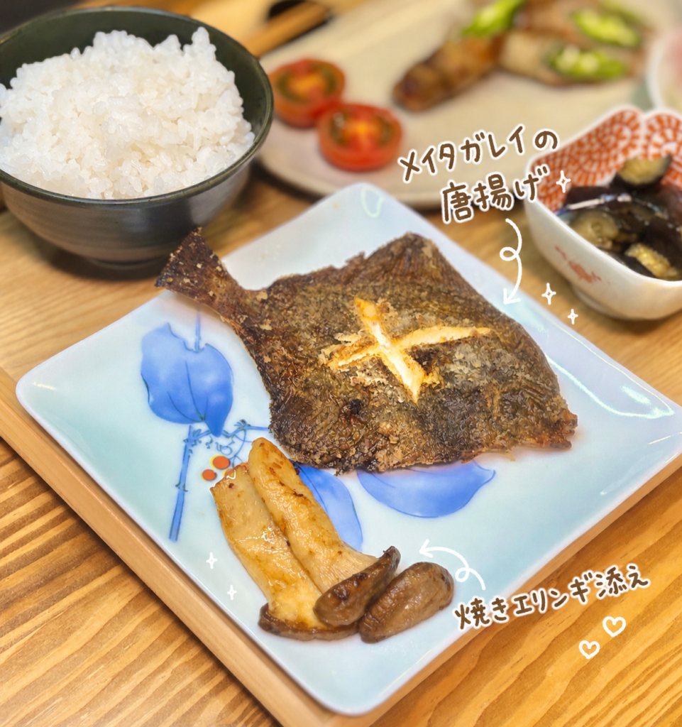 メイタガレイの唐揚げと焼きエリンギを青い角皿に盛り付けた写真。手書き風の文字で料理名を紹介し、香ばしく揚がったメイタガレイと焼きエリンギの組み合わせが伝わる、魚料理メインの和食おかず画像。