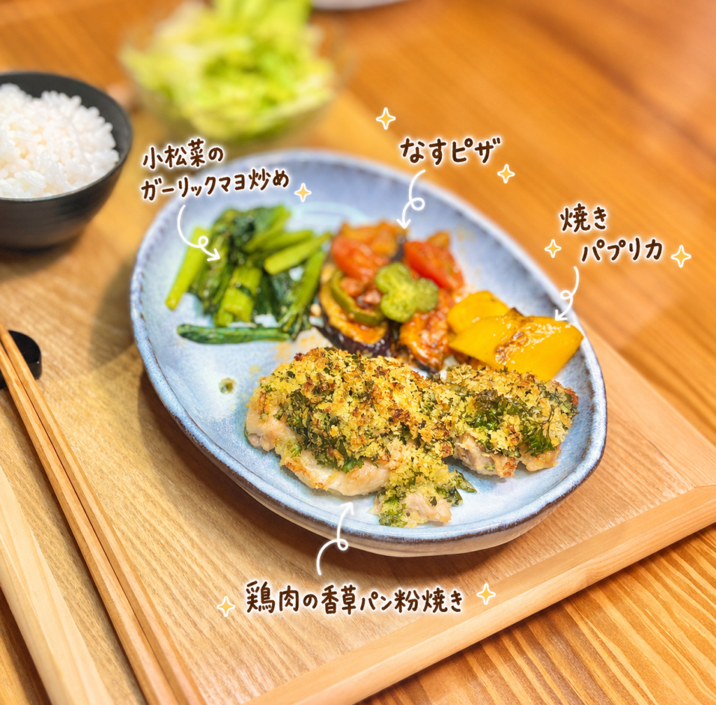 シロさん風の鶏肉の香草パン粉焼き、なすを生地に見立てたピザ、小松菜のガーリックマヨネーズ炒め、焼きパプリカ、野菜サラダを盛り付けた料理写真。手書き風の文字でそれぞれの料理名を紹介した、香草パン粉焼きと野菜副菜が楽しめる旦那キッチンの晩ごはん画像
